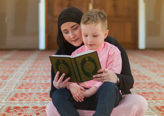 Child and mother reading koran in mosque