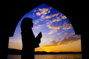 Silhouette of a girl praying in mosque